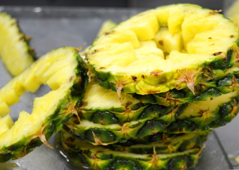 a closeup of a stack of sliced pineapple with stars cut out of the centers of the slices