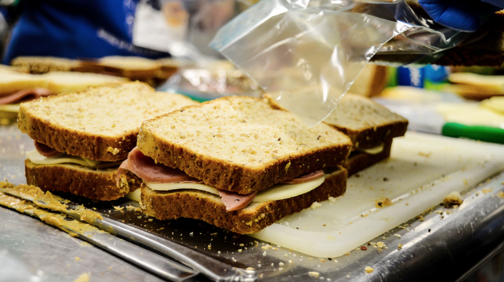 sandwiches being prepared on a prep table